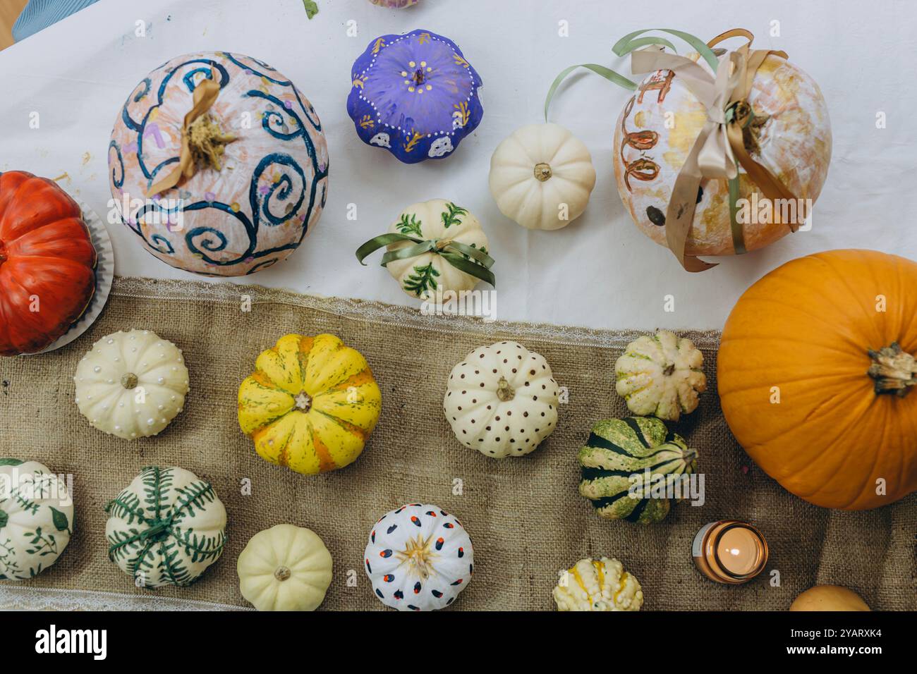 Enfants et adultes peignant des citrouilles pour Halloween, profitant d'une activité amusante et créative ensemble. Photo de haute qualité Banque D'Images