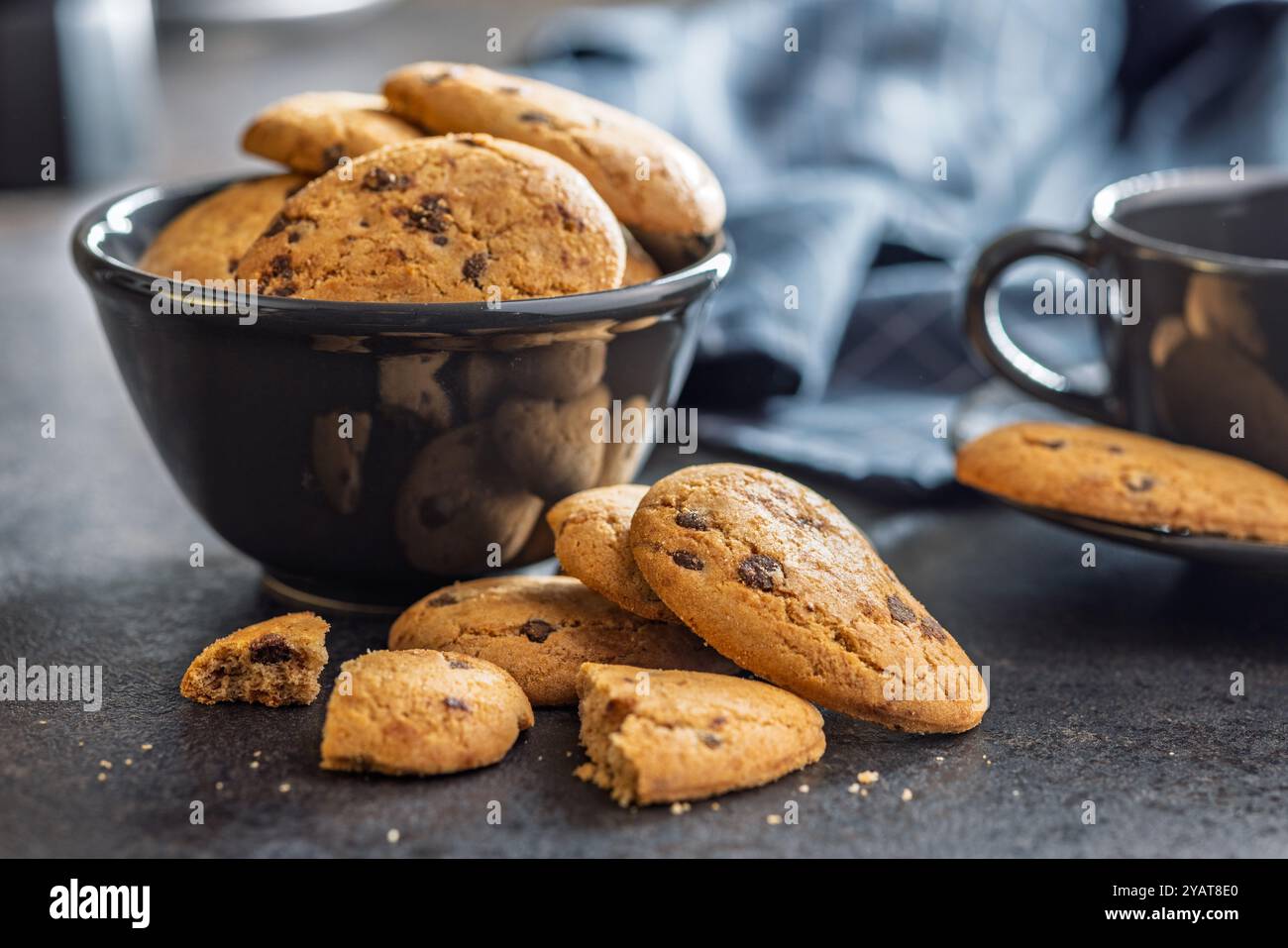 Biscotti frollini con gocce di cioccolato. Biscuits au chocolat sur une table noire. Banque D'Images