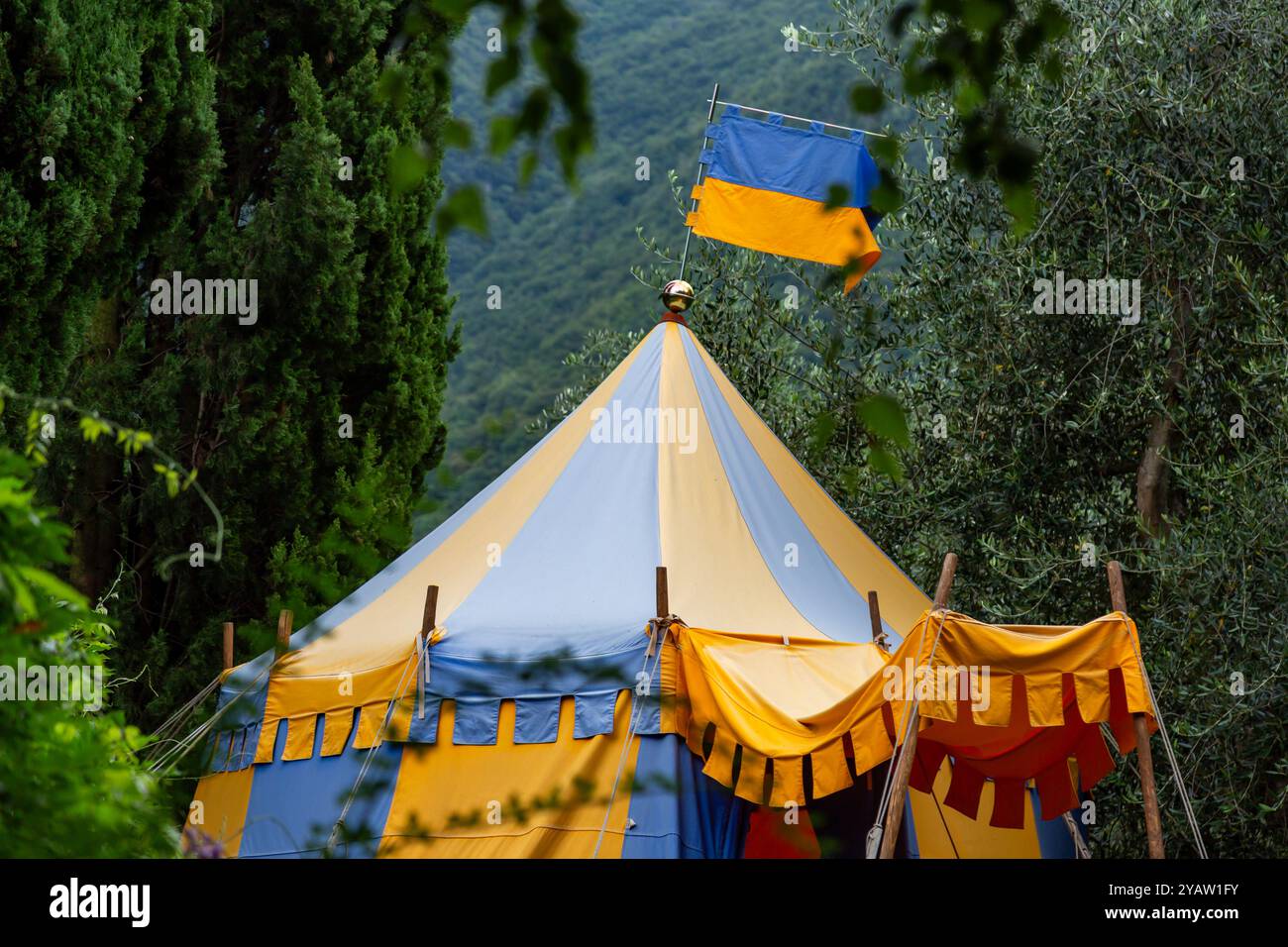Tente et drapeau de cirque bleu et jaune de style médiéval à Perledo, Lombardie, Italie Banque D'Images