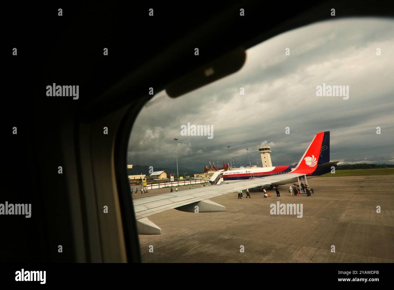 Un avion de Sriwijaya Air d'Indonésie est visible de l'intérieur de la cabine d'un avion de Lion Air à l'aéroport international de Minangkabau à Padang, Sumatra Ouest, Indonésie. Banque D'Images