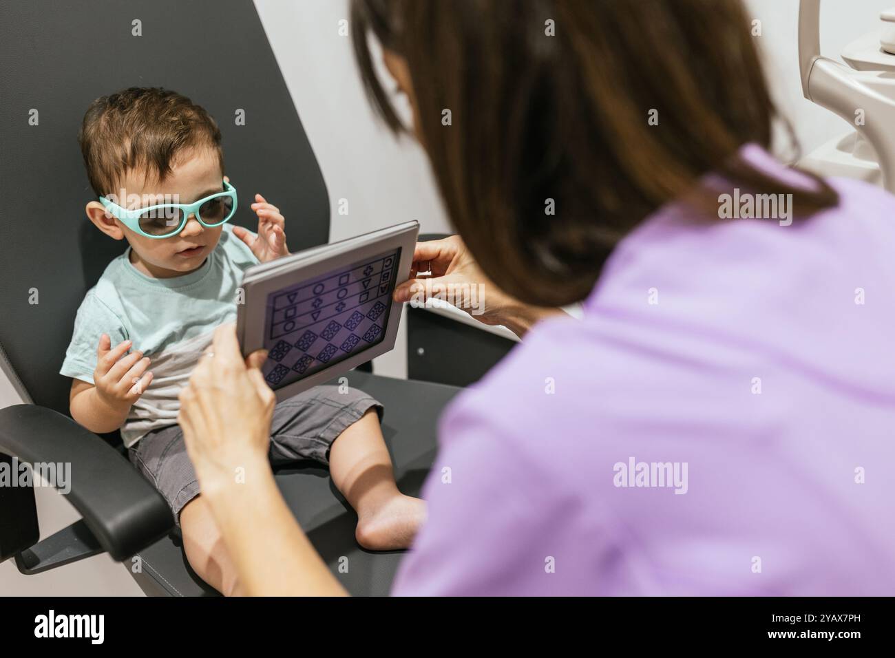 Optométriste pédiatrique examinant les yeux du bébé garçon en clinique Banque D'Images