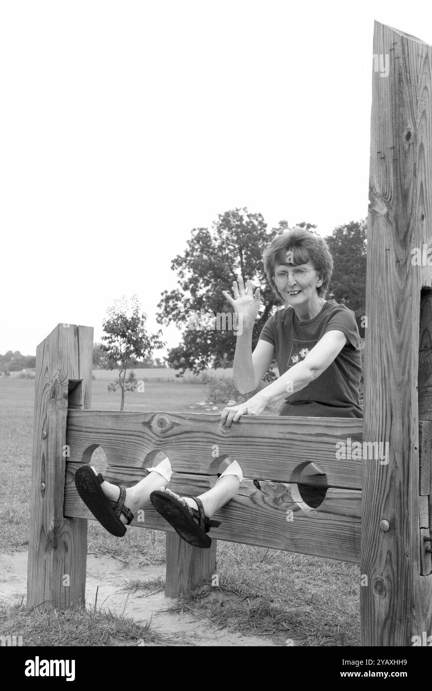 Une heureuse femme de 55 à 60 ans fait signe de la vague et profite de sa visite au Revolutionary War Park à Camden, en Caroline du Sud. Banque D'Images