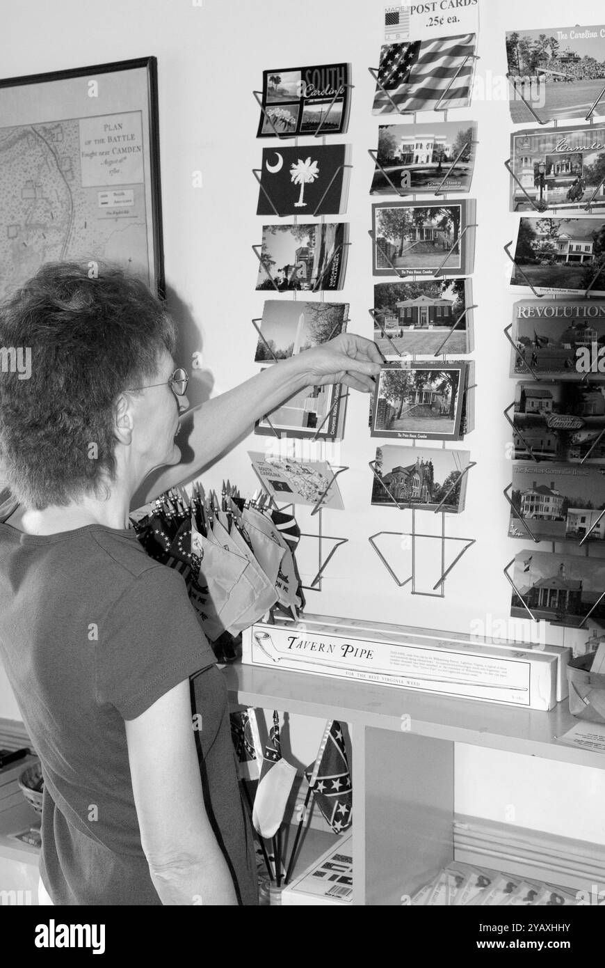 Une femme âgée, de 55 à 60 ans, regardant des cartes postales dans une boutique de cadeaux dans le Revolutionary War Park, Camden, Caroline du Sud, États-Unis. Banque D'Images