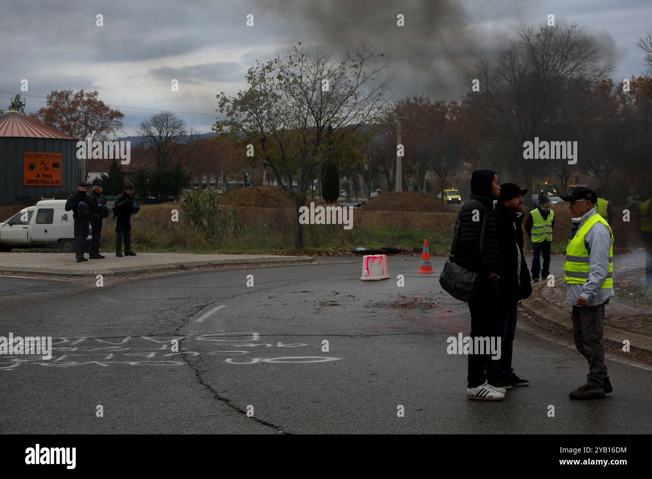 Les fourgonnettes de police se déplacent près des manifestants « gilets jaunes » situés près du rond-point près de l'autoroute de Manosque pour perturber leur sit-in afin de protester contre la hausse du prix du carburant. Ils manifestent dans la région depuis plus de dix jours, installant des tentes, stockant du bois pour le chauffage ainsi que des fournitures de nourriture et de boissons. Nommés d'après leur tenue de haute visibilité distinctive, les « gilets jaunes » ont protesté au cours des deux dernières semaines en France contre l'augmentation du prix du carburant dans le pays Banque D'Images