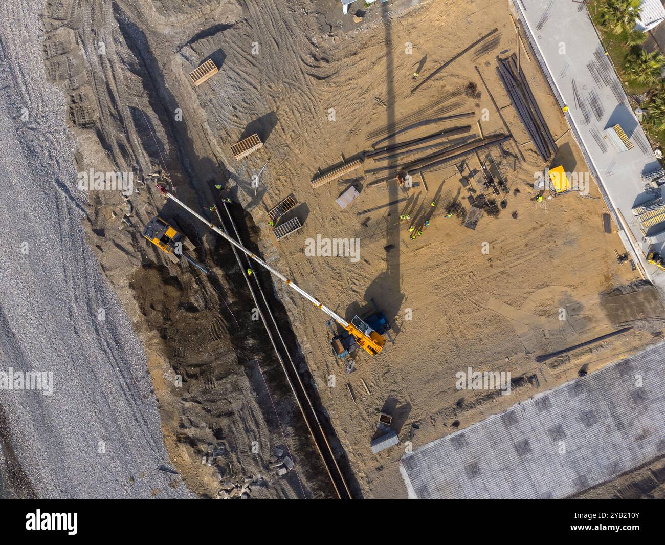Travaux de construction au bord de la mer. La machinerie lourde travaille à renforcer les fondations de l'eau et des vagues de tempête. Vue depuis le drone. Banque D'Images