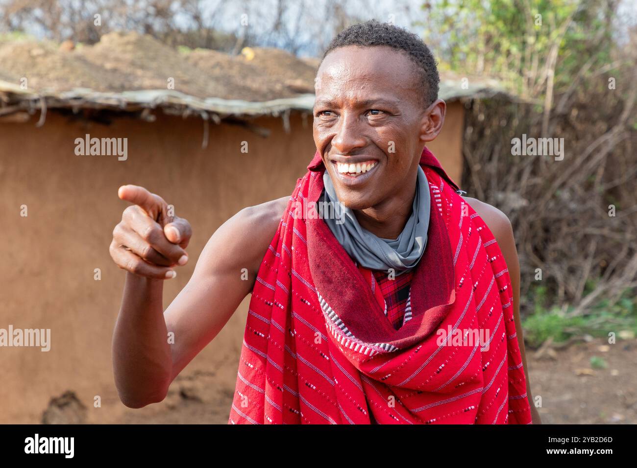 Membre masculin de la tribu Masai, vêtu de vêtements rouges traditionnels. Masai Mara, Kenya, Afrique Banque D'Images