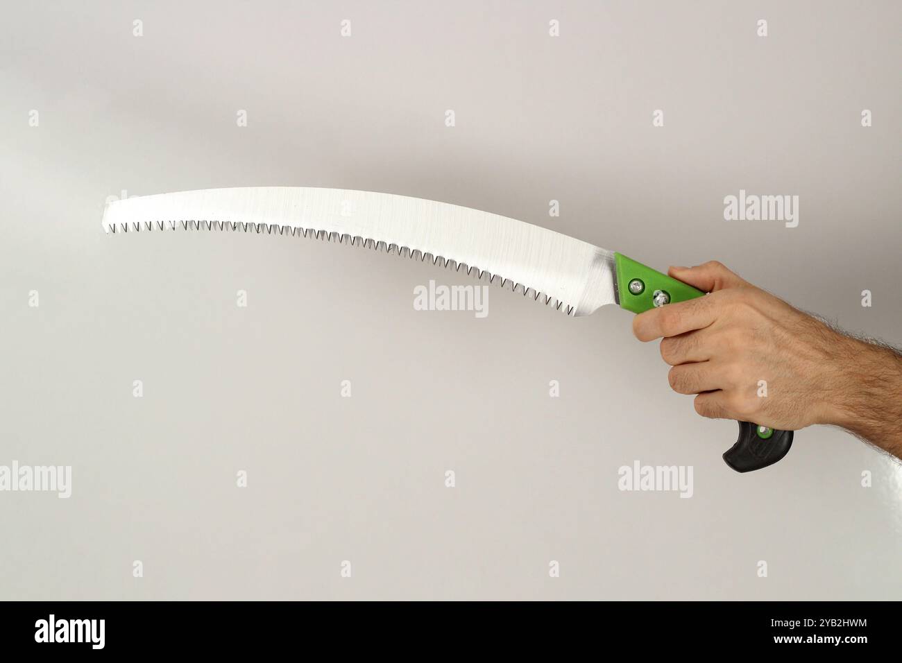 Homme tenant scie d'élagage isolé sur fond blanc. Gros plan. Banque D'Images