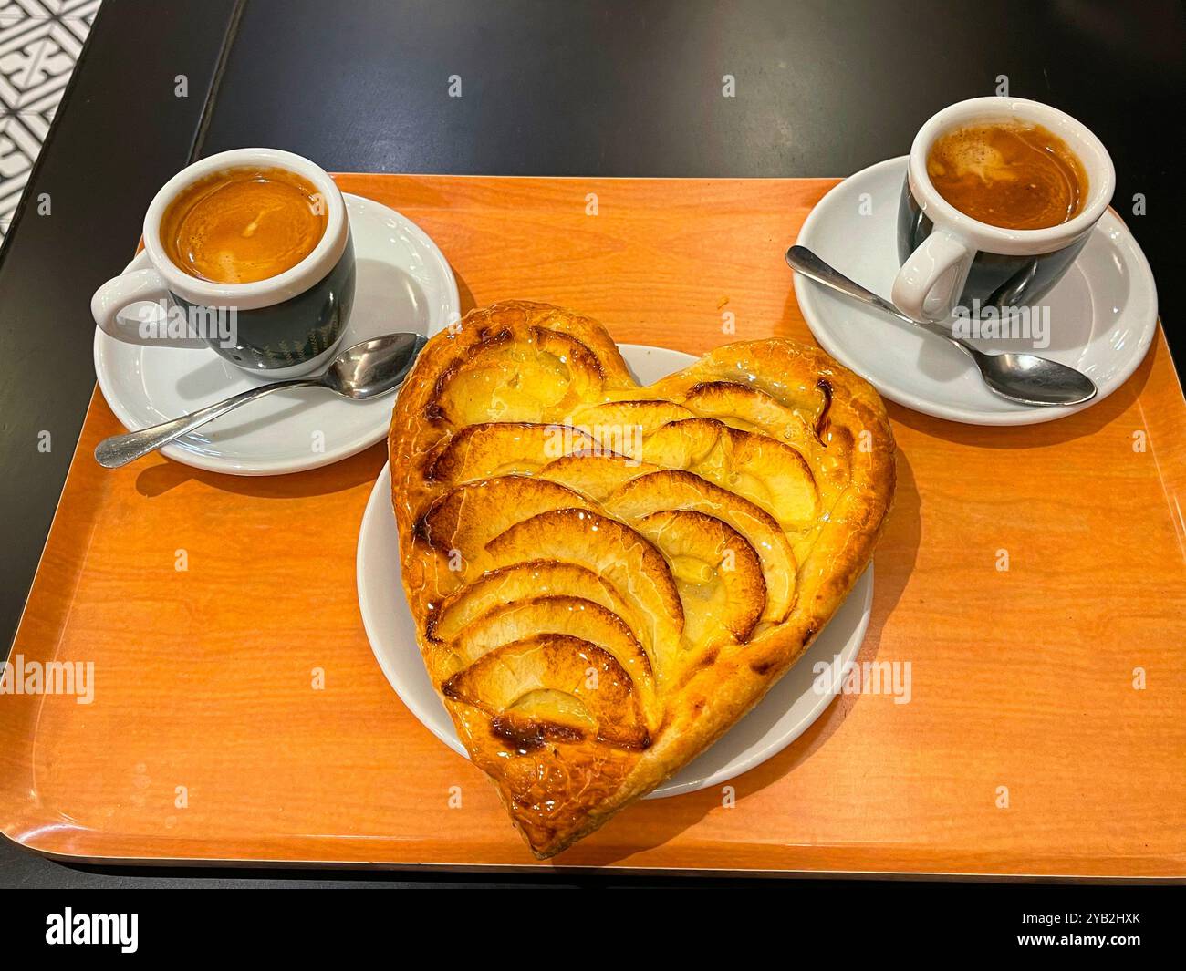 Gâteau aux pommes en forme de cœur et deux tasses de café. Banque D'Images