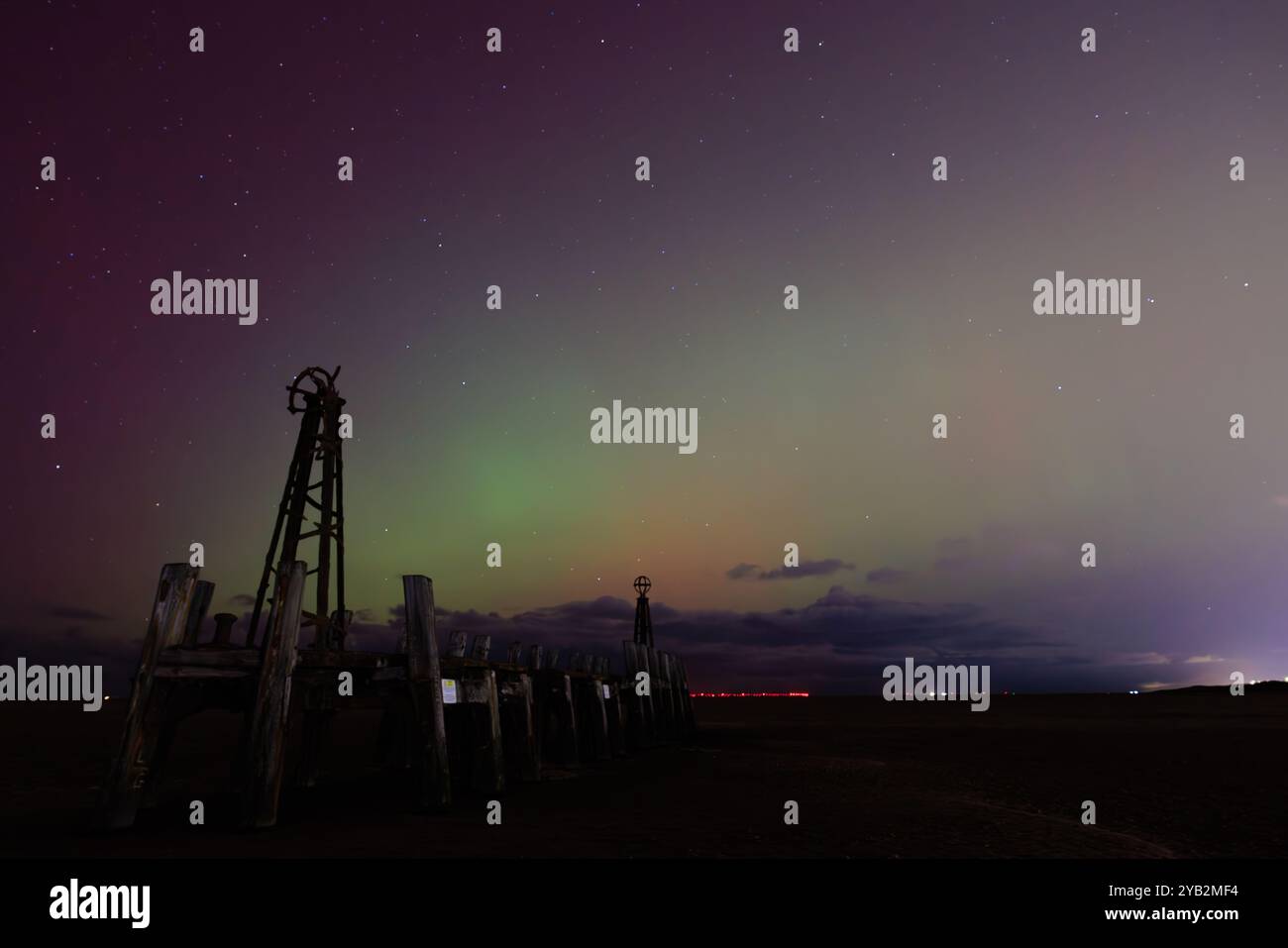 couleurs spectaculaires de rouge et vert dans le ciel nocturne depuis les aurores au-dessus de la jetée d'atterrissage en bois en ruine au bout de l'embarcadère lytham st annes en angleterre Banque D'Images