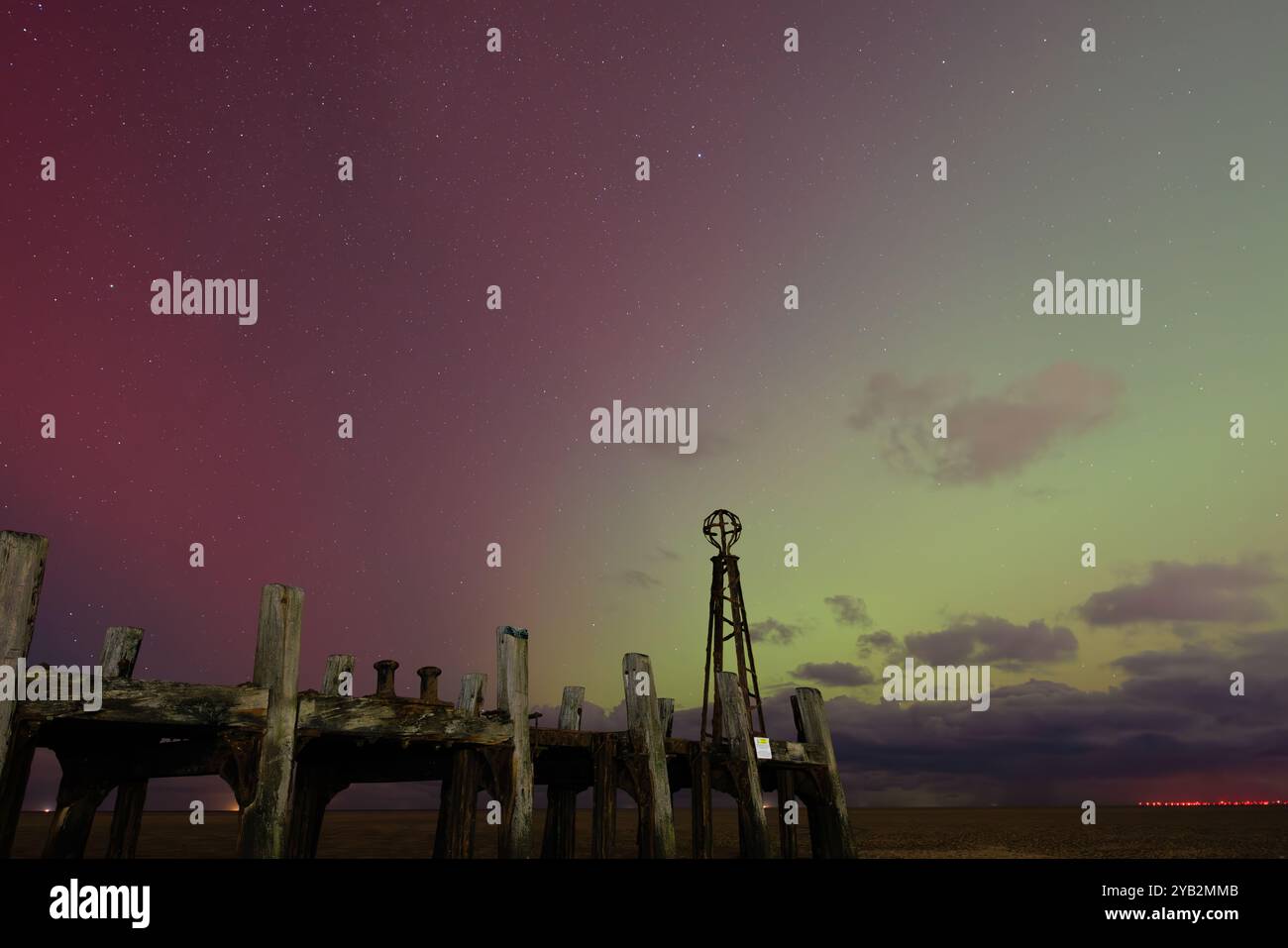 couleurs spectaculaires de rouge et vert dans le ciel nocturne depuis les aurores au-dessus de la jetée d'atterrissage en bois en ruine au bout de l'embarcadère lytham st annes en angleterre Banque D'Images