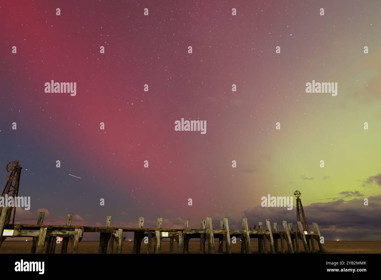 couleurs spectaculaires de rouge et vert dans le ciel nocturne depuis les aurores au-dessus de la jetée d'atterrissage en bois en ruine au bout de l'embarcadère lytham st annes en angleterre Banque D'Images
