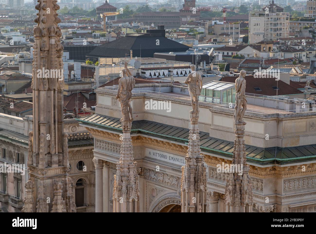 Une photo du Duomo di Milano ou de la cathédrale de Milan, une flèche et une statue surplombant le toit de la Galleria Vittorio Emanuele II. Banque D'Images