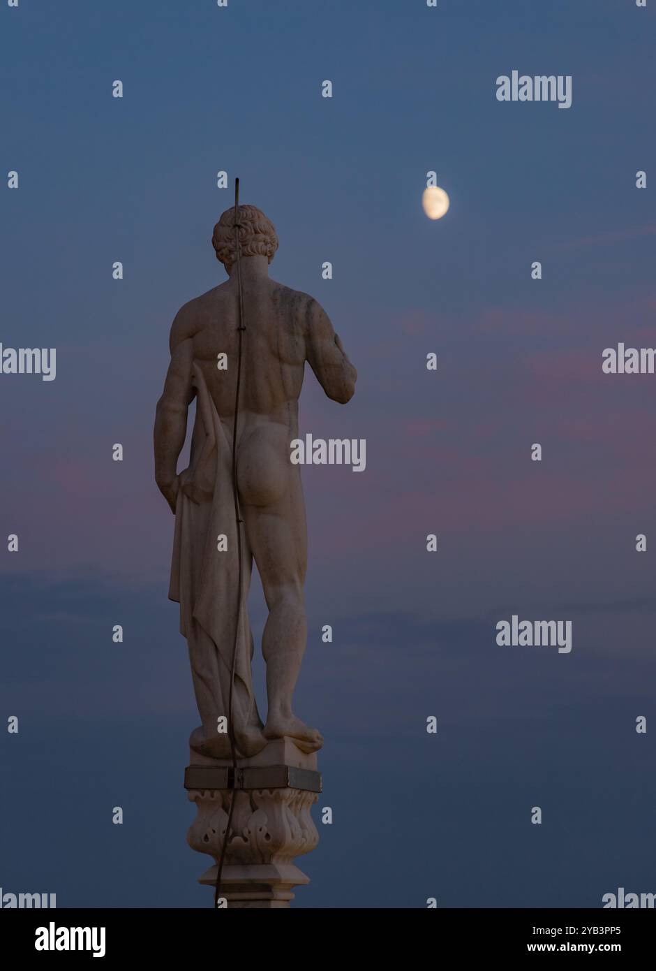 Une photo d'un Duomo di Milano ou statue de la cathédrale de Milan surplombant la lune au coucher du soleil. Banque D'Images