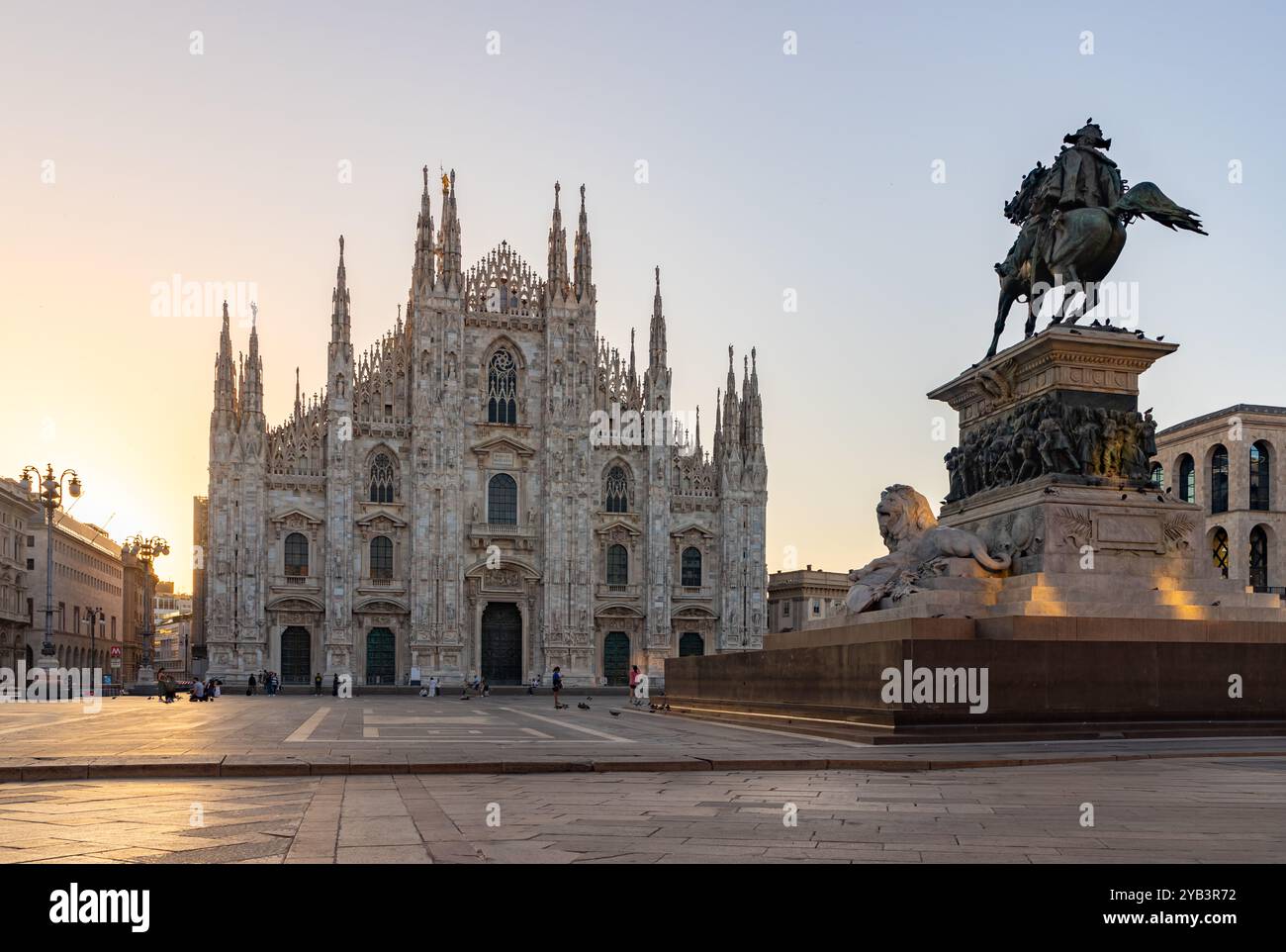 Une photo de la Piazza del Duomo au lever du soleil, avec le Duomo di Milano ou la Cathédrale de Milan sur la gauche et la statue Vittorio Emanuele II sur la droite Banque D'Images