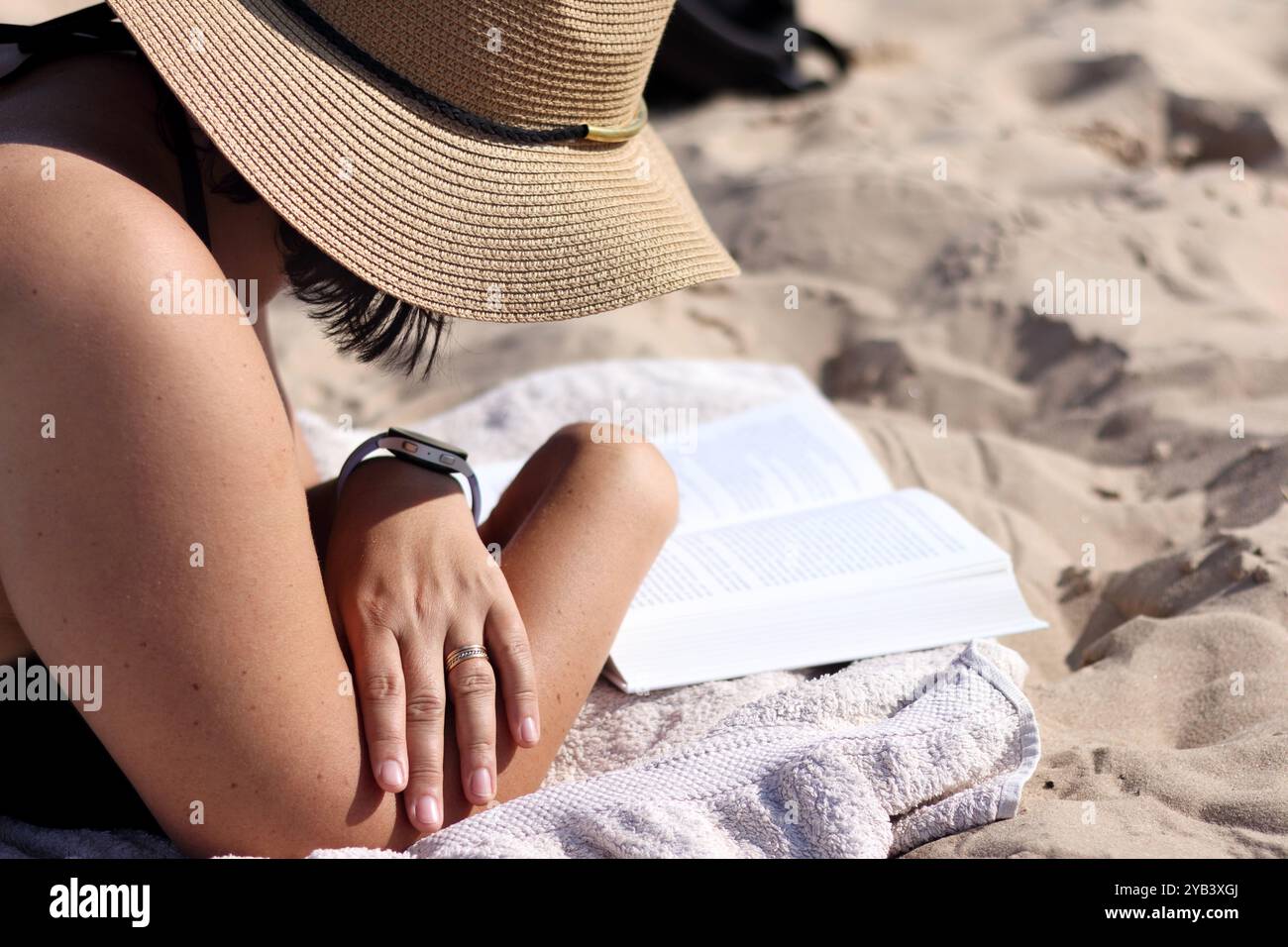 femme se relaxant sur la plage lisant un livre Banque D'Images