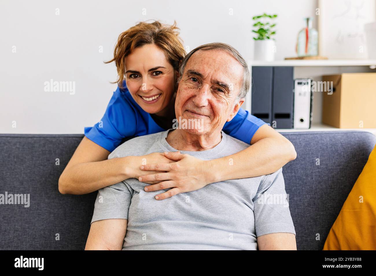 Portrait joyeux d'une soignante adulte moyenne embrassant une patiente âgée à domicile Banque D'Images Portrait joyeux d'une soignante adulte moyenne embrassant une patiente âgée à domicile Banque D'Images