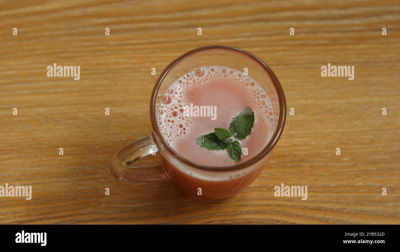 Jus de pastèque garni de menthe rafraîchissant dans une tasse en verre Banque D'Images