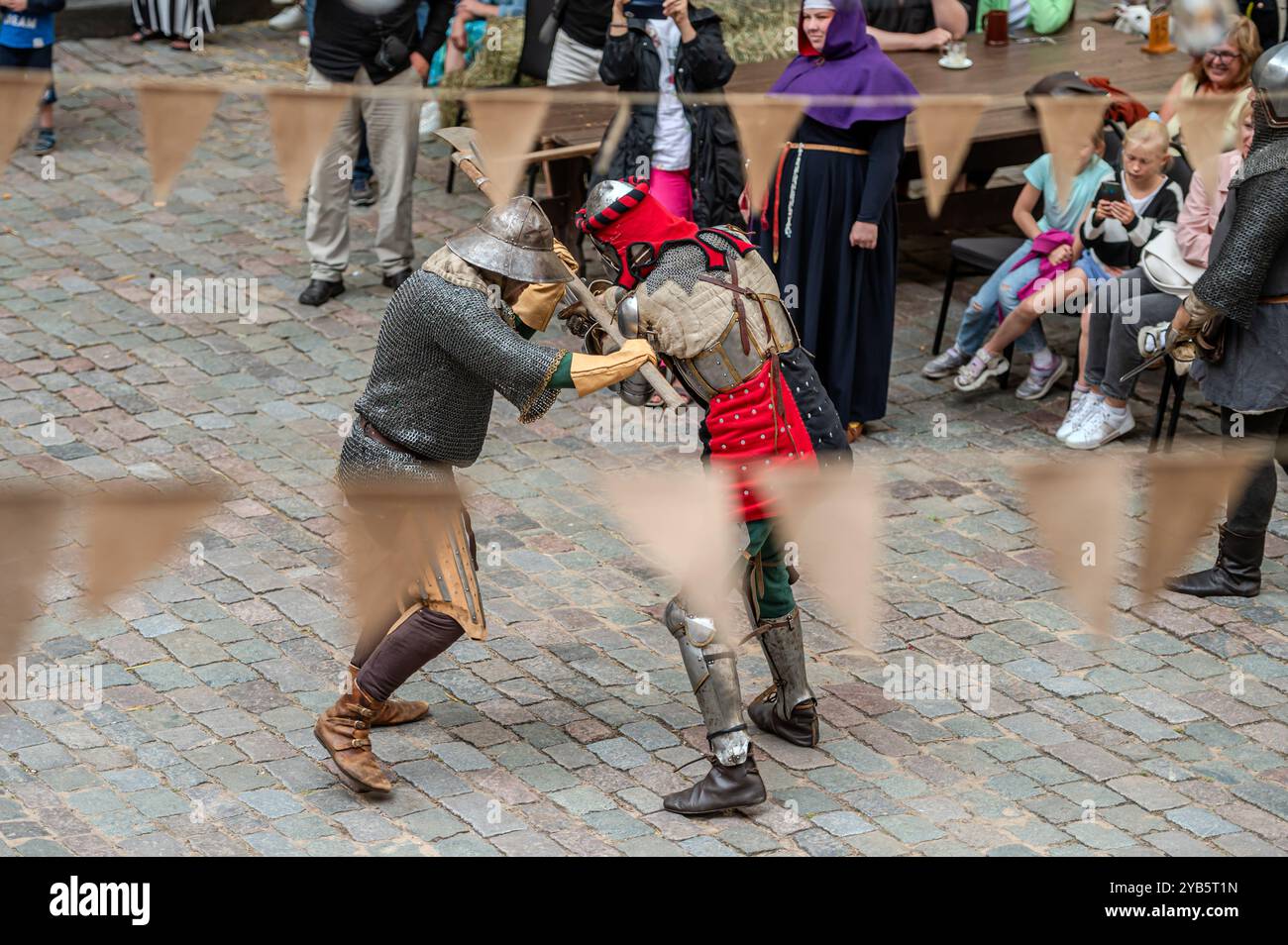 Jaunpils, Lettonie - 10 août 2024 : les chevaliers s'engagent dans un duel amical au milieu d'une foule festive. Banque D'Images