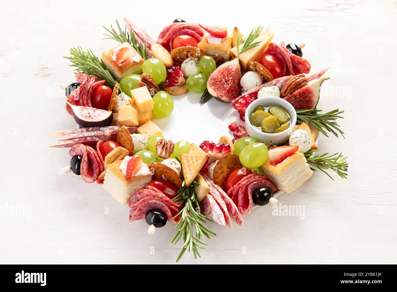 Couronne de Noël de collations festives. Canapés au fromage avec légumes et salami sur fond blanc. Couronne de nourriture de Noël. Vue de dessus. Banque D'Images Couronne de Noël de collations festives. Canapés au fromage avec légumes et salami sur fond blanc. Couronne de nourriture de Noël. Vue de dessus. Banque D'Images