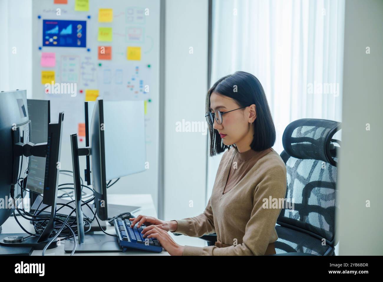 femme asiatique développeur programme de codage ai dans le bureau moderne Banque D'Images