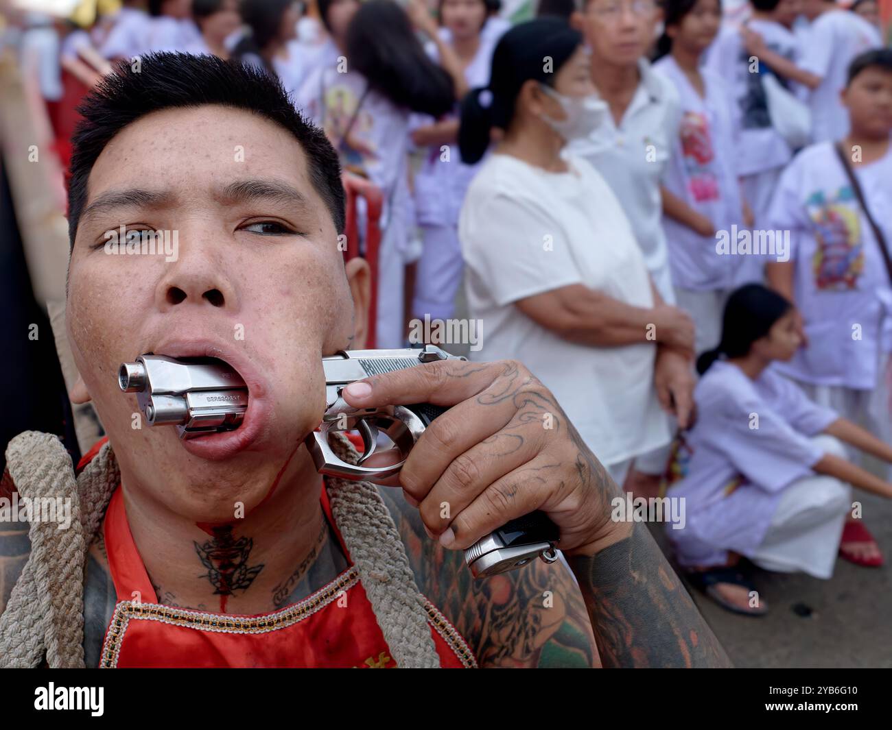 Au cours du festival végétarien annuel Gory à Phuket Town, en Thaïlande, une chanson de mAh (medium spirituel) montre un pistolet poussé à travers une coupure dans sa joue Banque D'Images