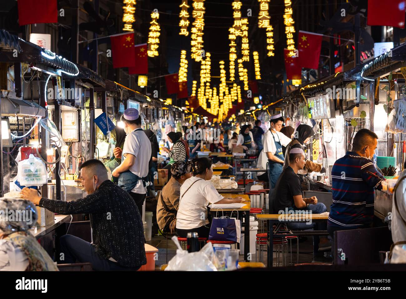 Lanzhou, Chine - 24 septembre 2024 : les gens apprécient la cuisine chinoise dans la rue Dazhong Xiang la nuit célèbre pour son stand de nourriture dans la ville de Lanzhou en Géorgie Banque D'Images