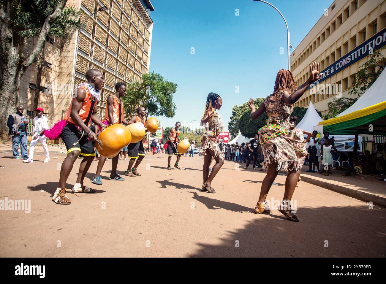 Les artistes divertissent les gens avec des danses traditionnelles dans la rue pendant le carnaval de Kampala City Banque D'Images