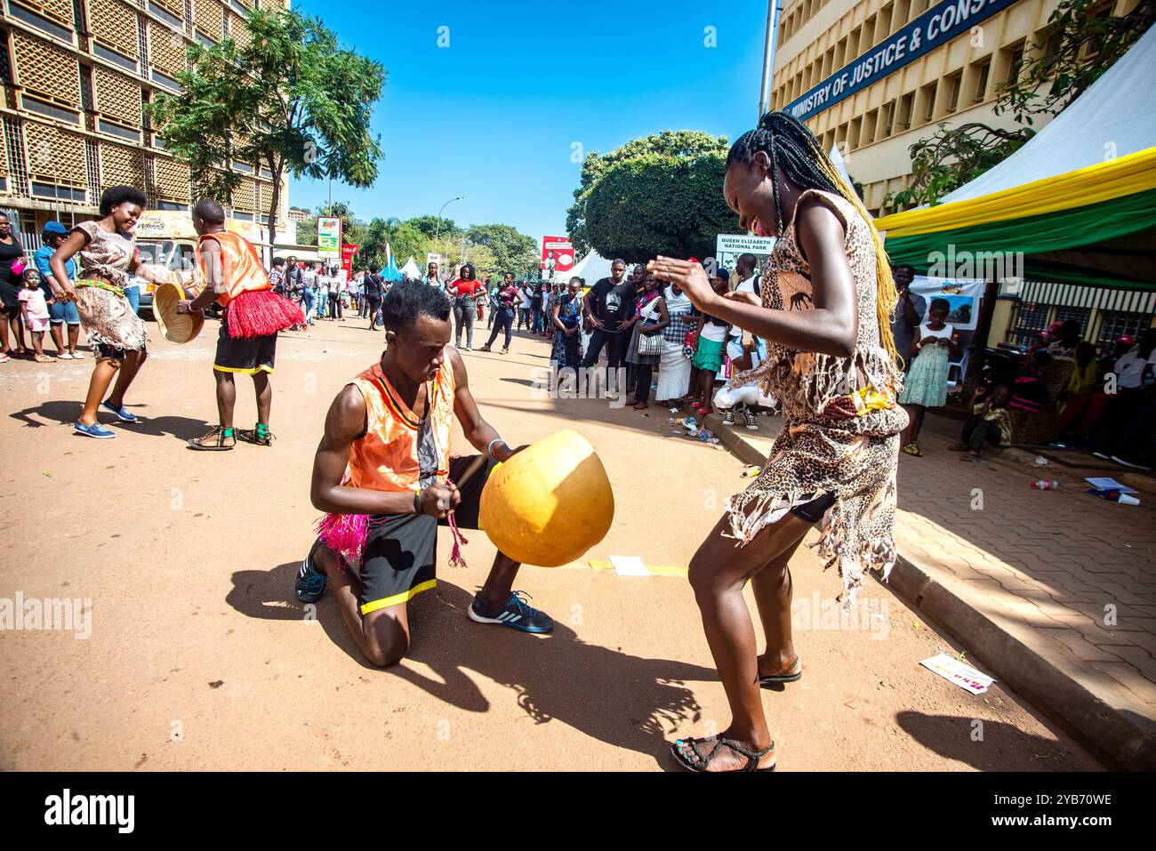 Les artistes divertissent les gens avec des danses traditionnelles dans la rue pendant le carnaval de Kampala City Banque D'Images