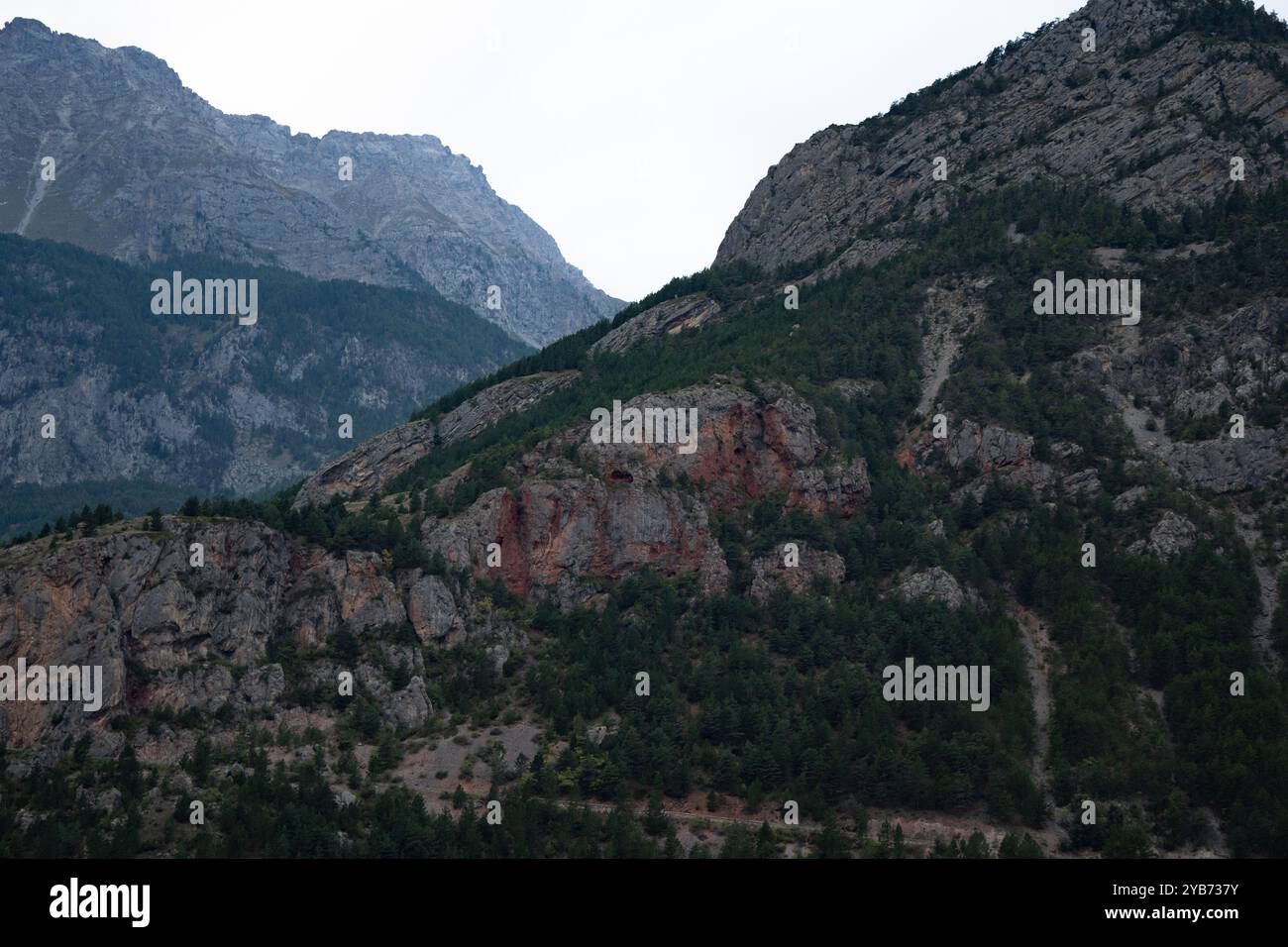 Un paysage montagneux avec des rochers abrupts et une forêt verdoyante, offrant une vue panoramique sur la nature sauvage et préservée. Banque D'Images