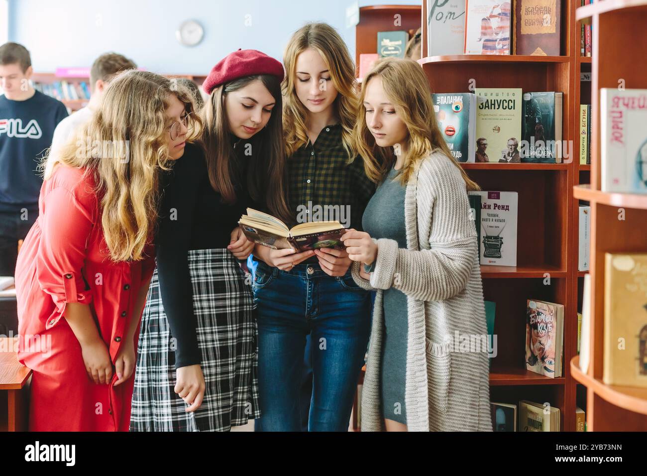 Romny, Ukraine, 29 septembre 2019 : des jeunes femmes, des étudiants se tiennent debout dans un environnement confortable de bibliothèque et lisent un livre Banque D'Images