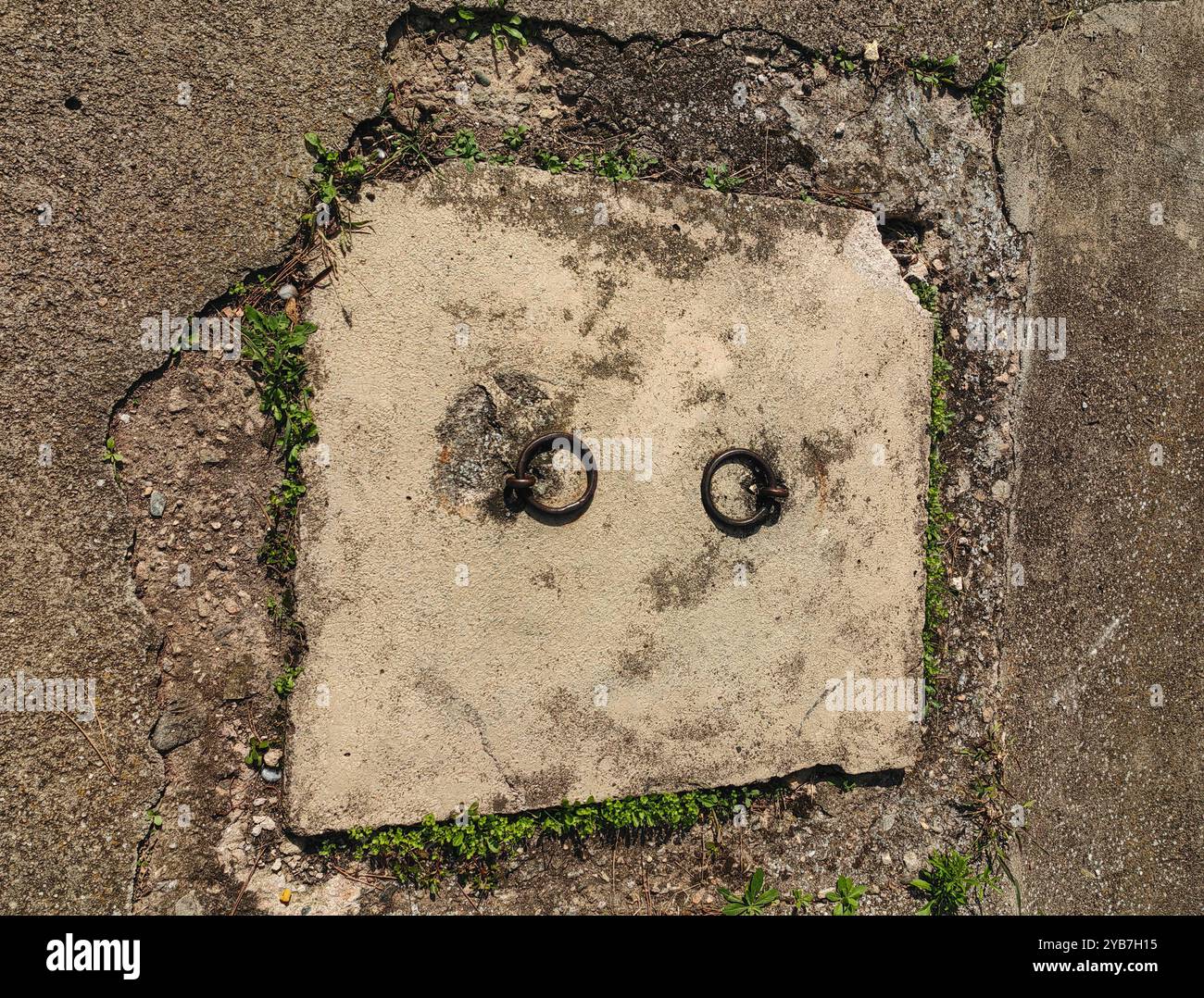 Yeux abstraits : cercles de traction en métal sur plaque de béton Banque D'Images