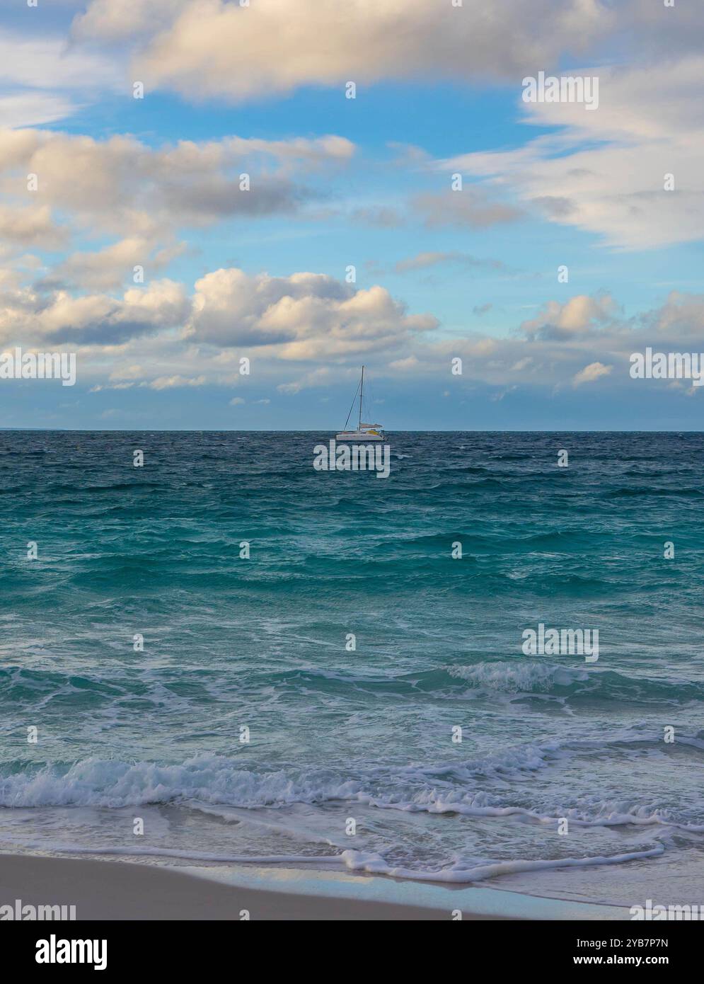 Voilier tranquille sur la mer ouverte sous un ciel nuageux Banque D'Images