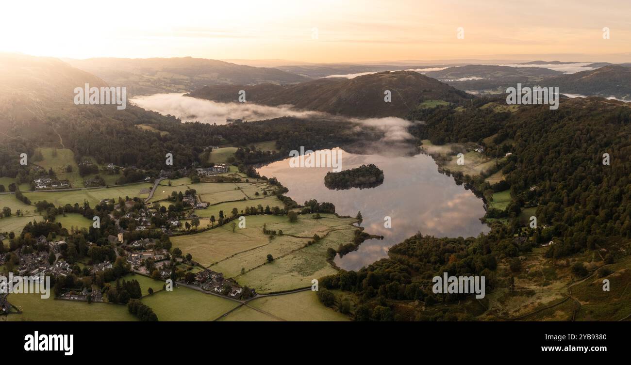 Paysage panoramique aérien du village du Lake District de Grasmere au-dessus du lac Grasmere avec une brume basse couchée par un matin froid, y compris les environs Mo Banque D'Images