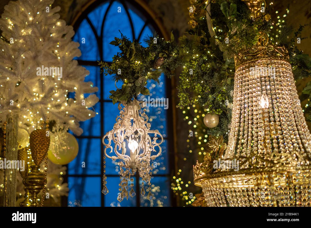 Un lustre élégant est accroché gracieusement au milieu de décorations festives, avec des lumières étincelantes illuminant l'espace lors d'une soirée de vacances confortable. Banque D'Images