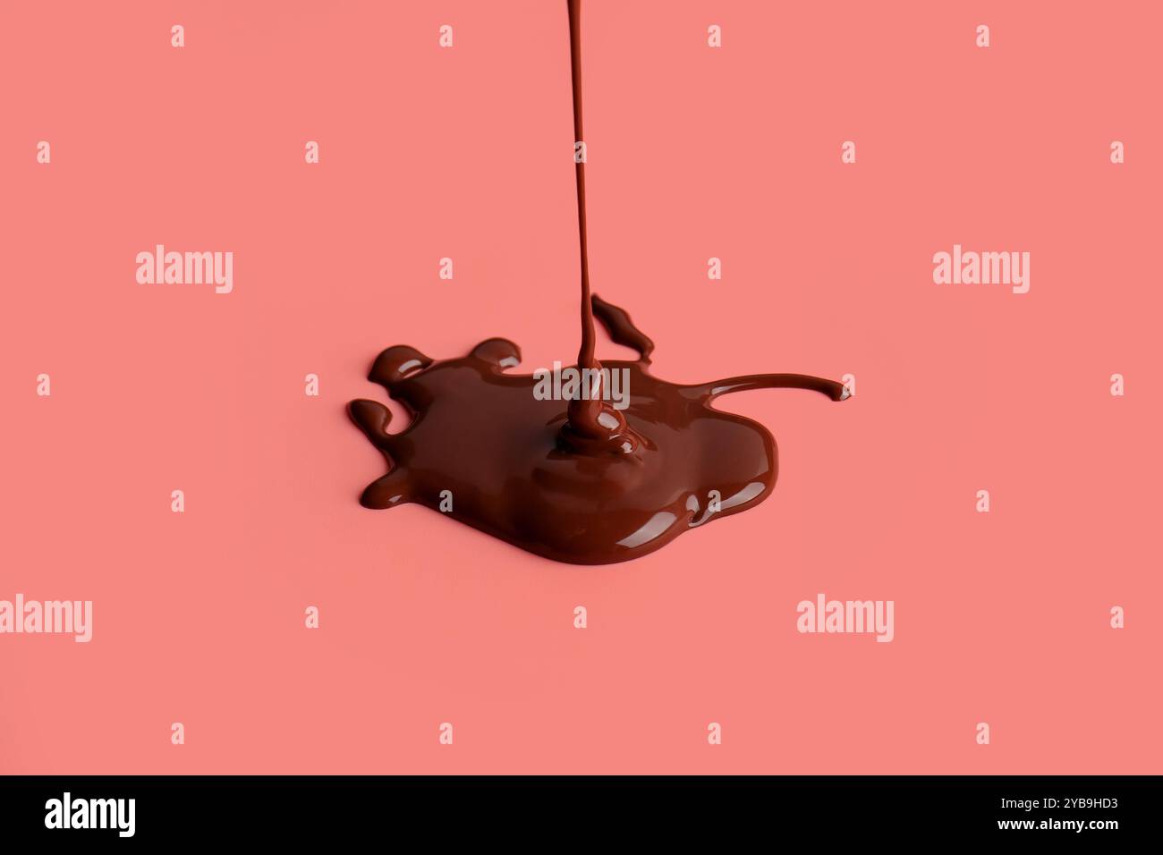 Goutte à goutte chocolat sucré sur fond rouge Banque D'Images