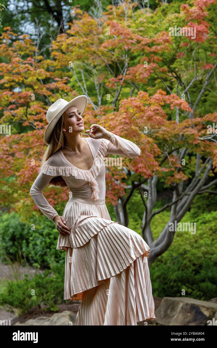 Un superbe modèle met en valeur la mode automnale au milieu de la beauté de la nature, dégageant élégance et charme dans une promenade pittoresque dans le parc Banque D'Images