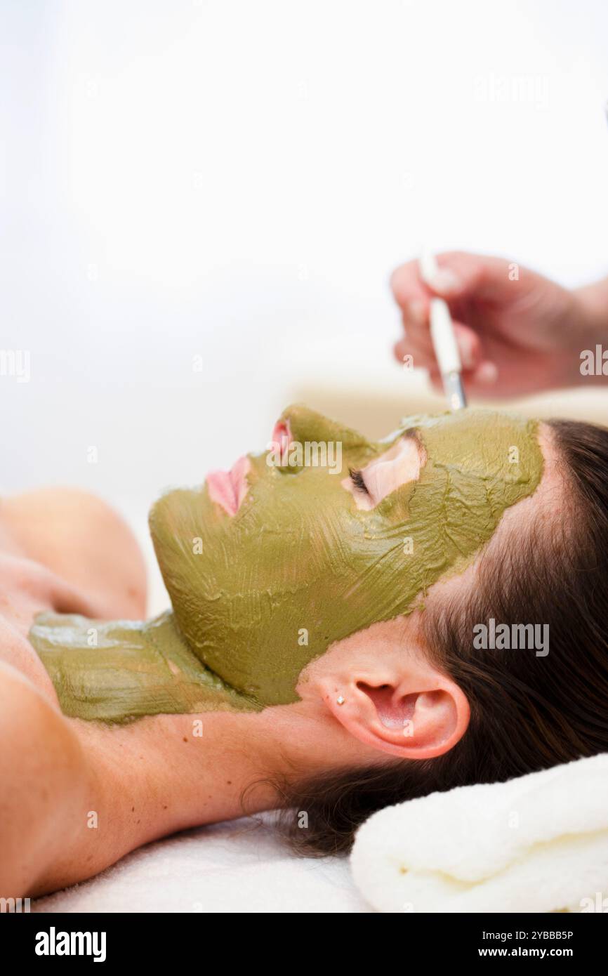 L'application de la main beauté masque vert sur le visage Banque D'Images