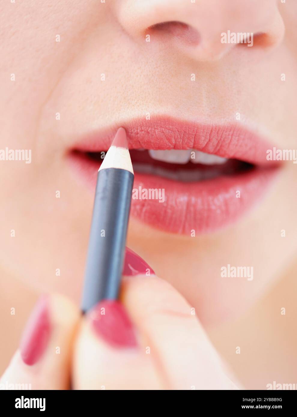 Vue rapprochée de la femme à l'aide d'un crayon à lèvres Banque D'Images