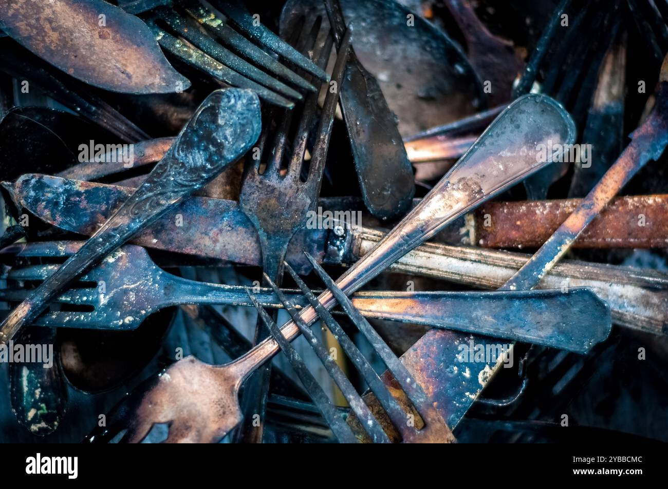 Photographie rapprochée de la pile carbonisée de restes d'argenterie provenant d'un incendie de maison. Banque D'Images