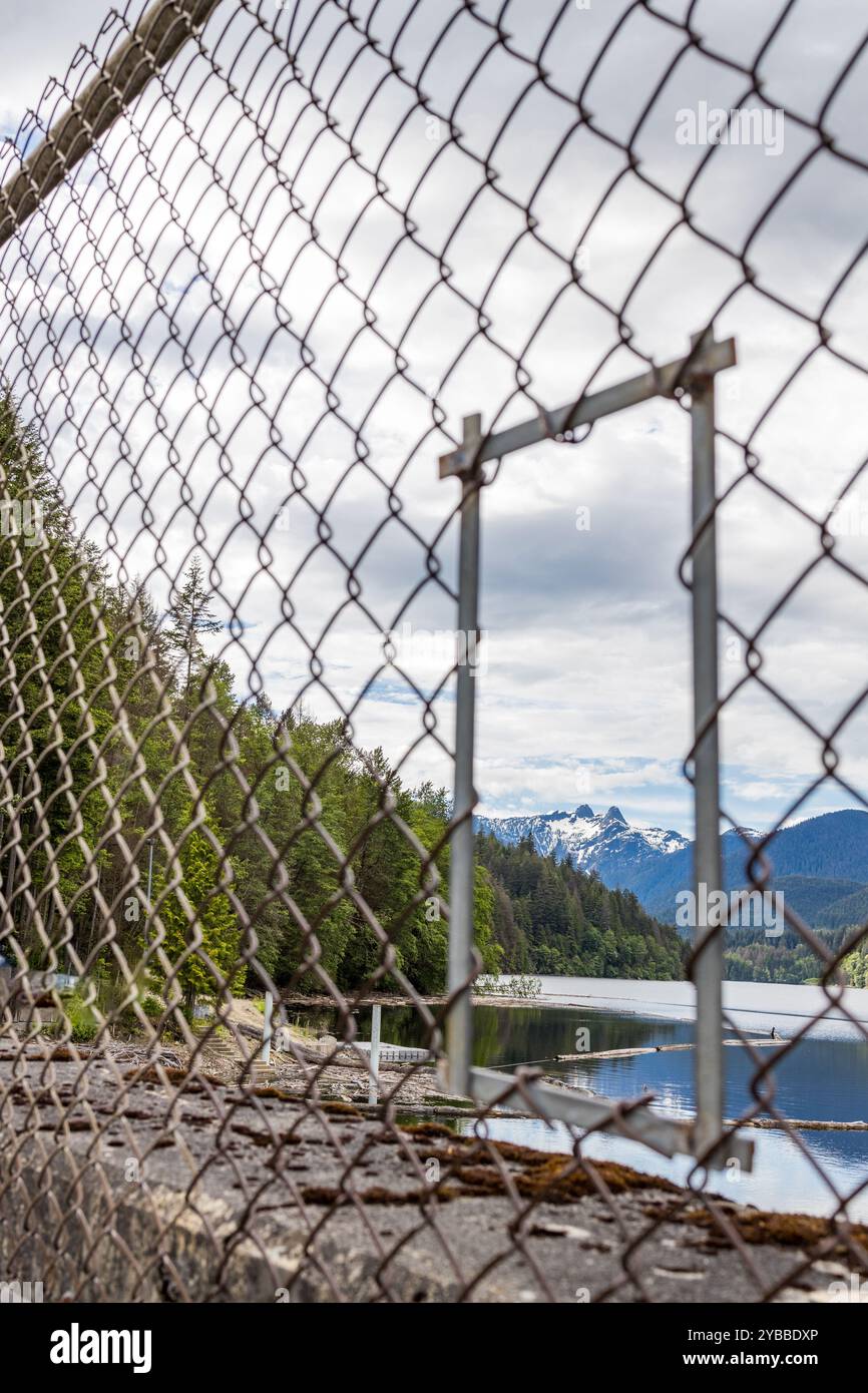 Une vue panoramique sur le réservoir du barrage de Cleveland encadré par une clôture à maillons, mettant en valeur les montagnes Twin Sisters Banque D'Images