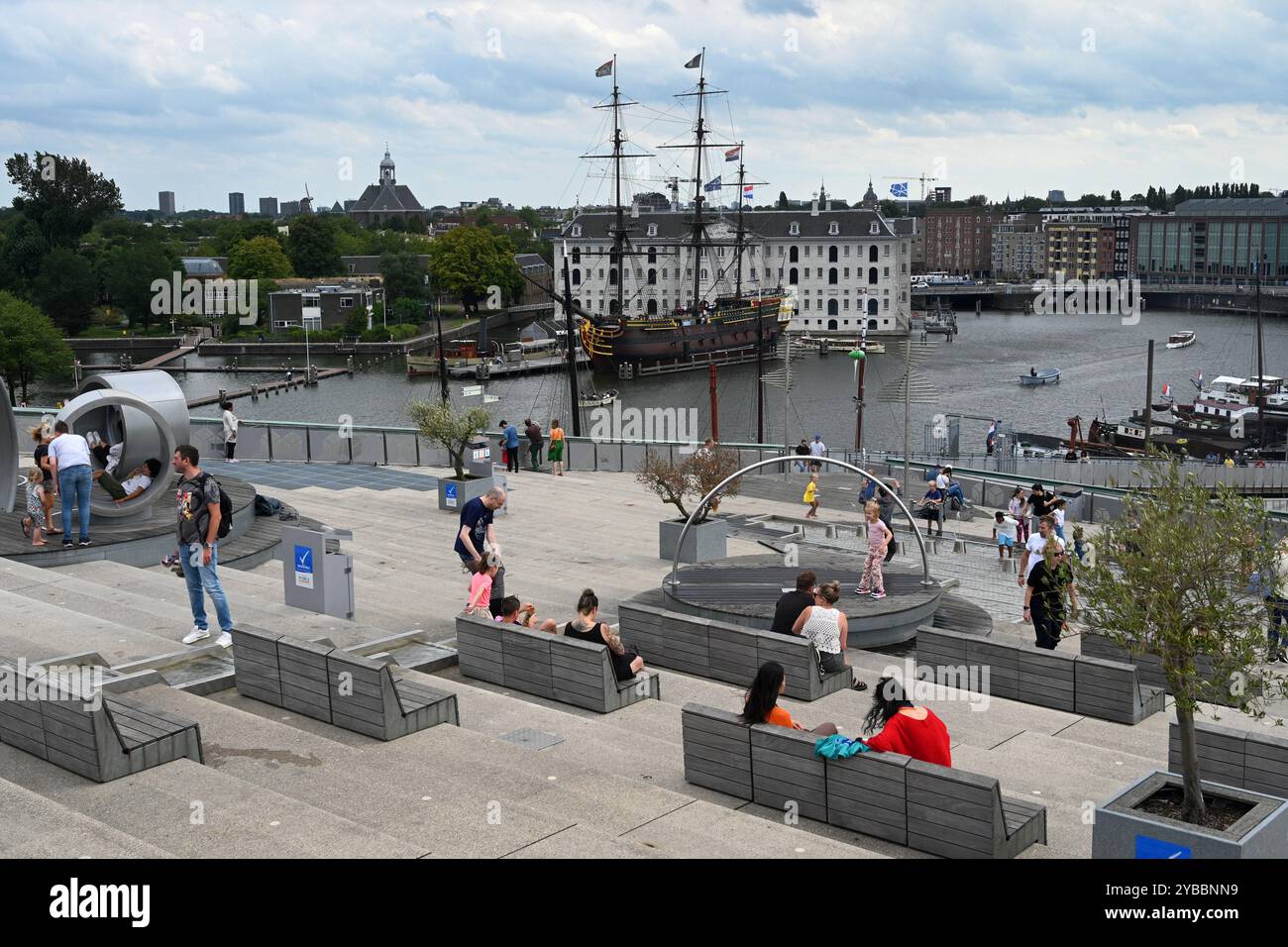 Amsterdam, pays-Bas - 24 août 2024 : les gens sur le toit du Musée des Sciences NEMO avec le Musée maritime en arrière-plan. Banque D'Images