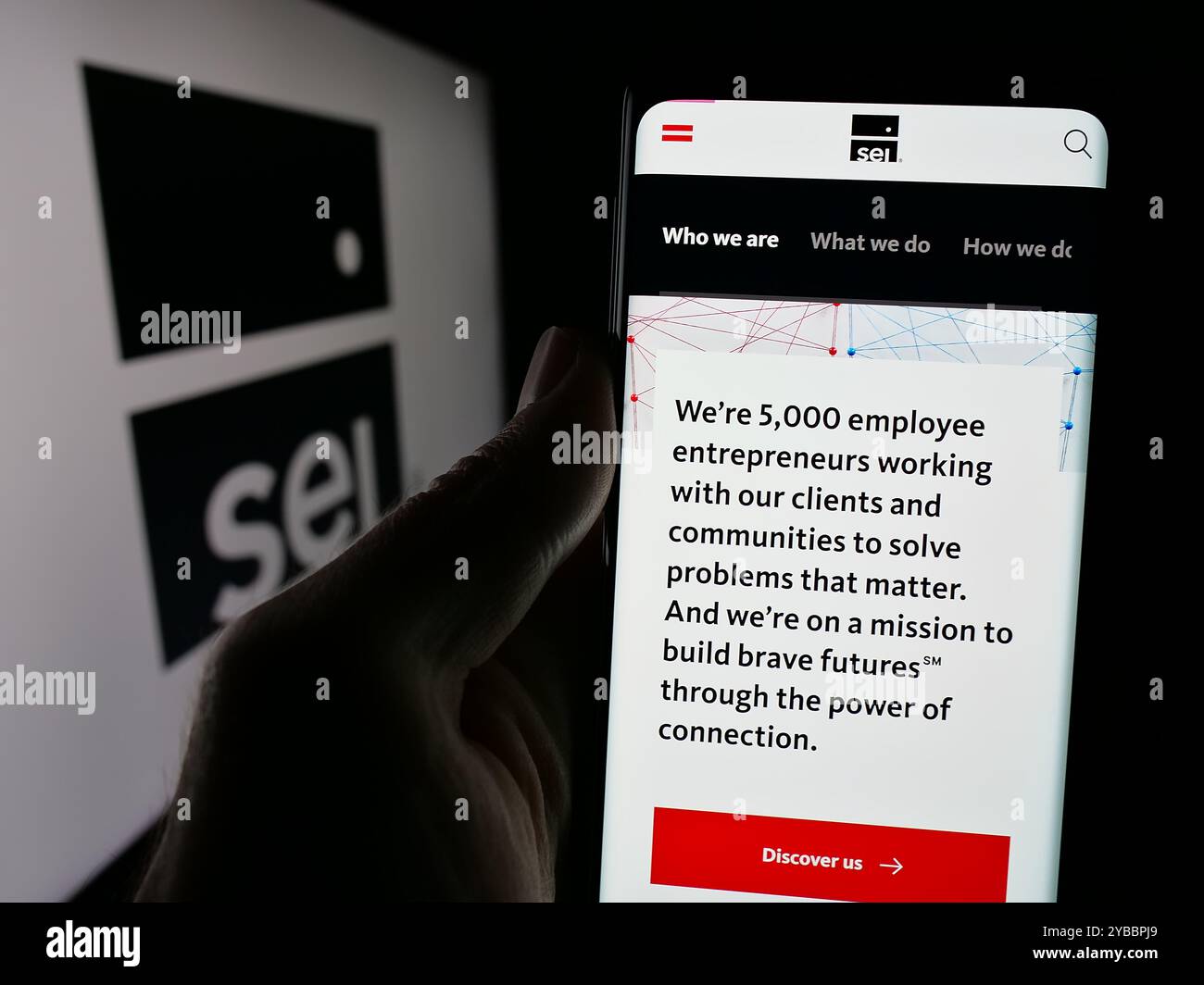 Personne tenant le téléphone portable avec la page Web des affaires américaines SEI Investments Company sur l'écran devant le logo. Concentrez-vous sur le centre de l'écran du téléphone. Banque D'Images
