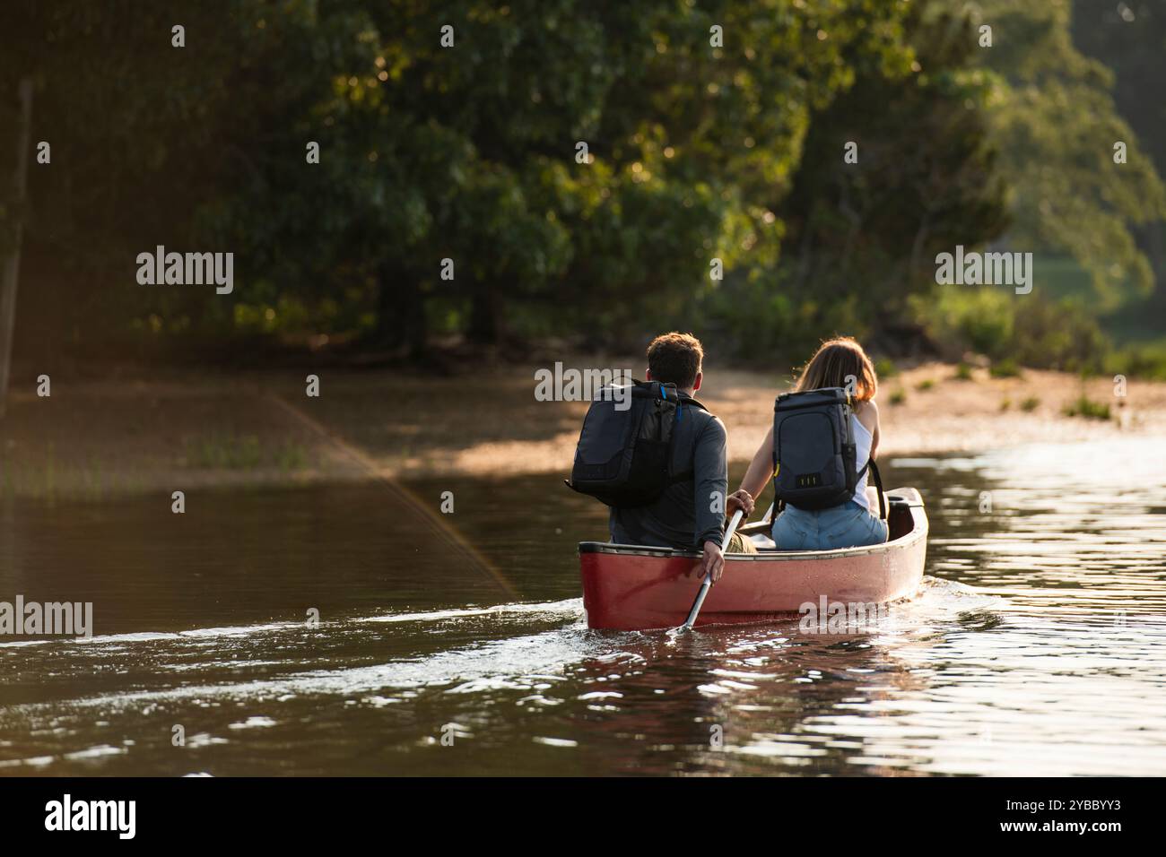 Couple avec sacs à dos pagaie canoë le jour d'été Banque D'Images
