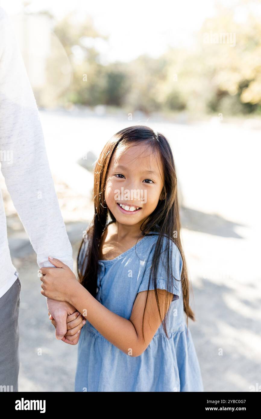 Gros plan d'une fille de neuf ans tenant la main de papa à San Diego Banque D'Images