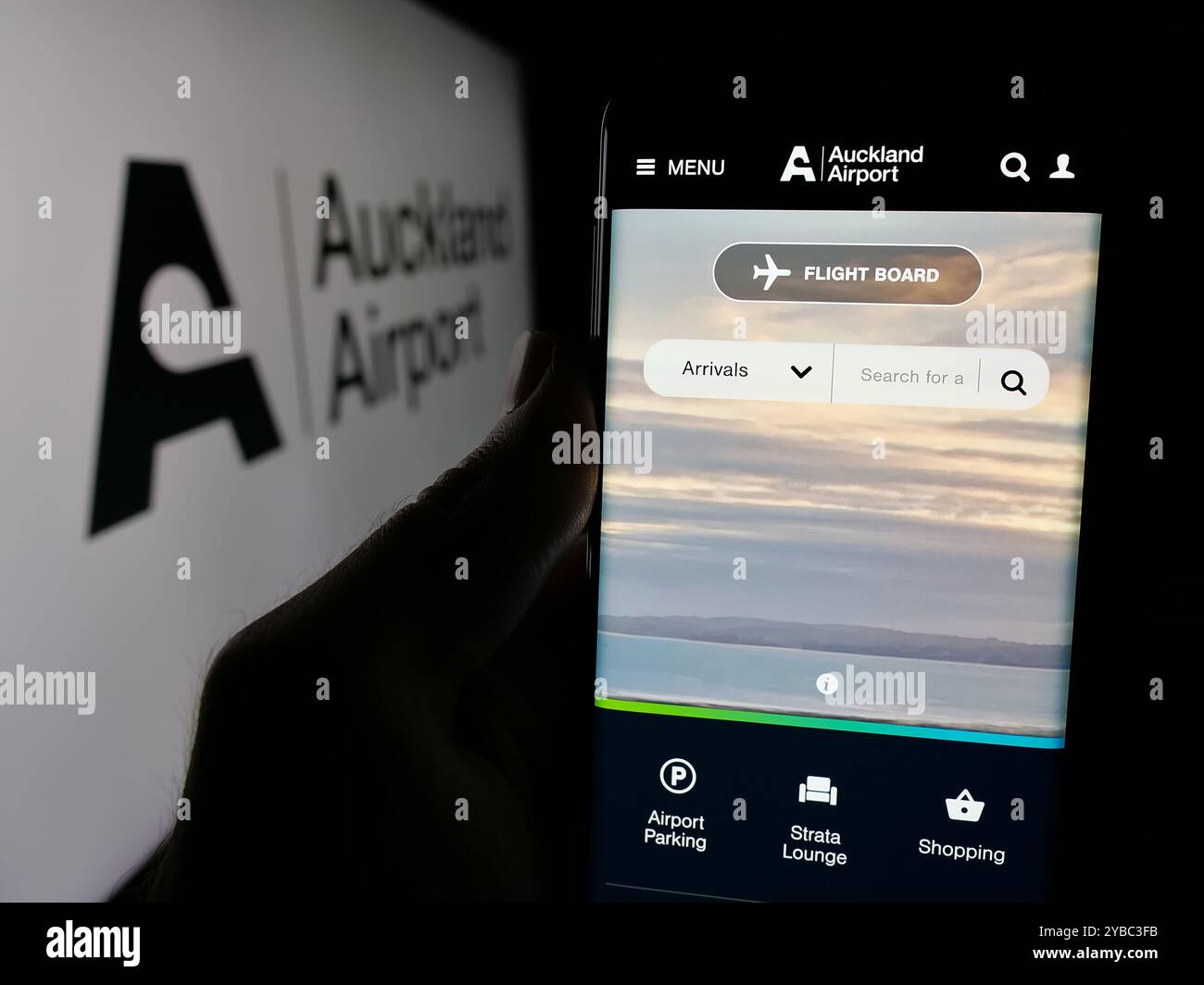 Personne tenant smartphone avec la page Web de la société Auckland International Airport Limited sur l'écran avec logo. Concentrez-vous sur le centre de l'écran du téléphone. Banque D'Images