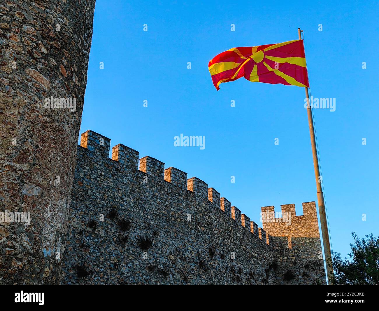 Drapeau macédonien agitant au-dessus de la forteresse de Samoil à Ohrid : une journée ensoleillée contre un ciel bleu clair Banque D'Images Drapeau macédonien agitant au-dessus de la forteresse de Samoil à Ohrid : une journée ensoleillée contre un ciel bleu clair Banque D'Images