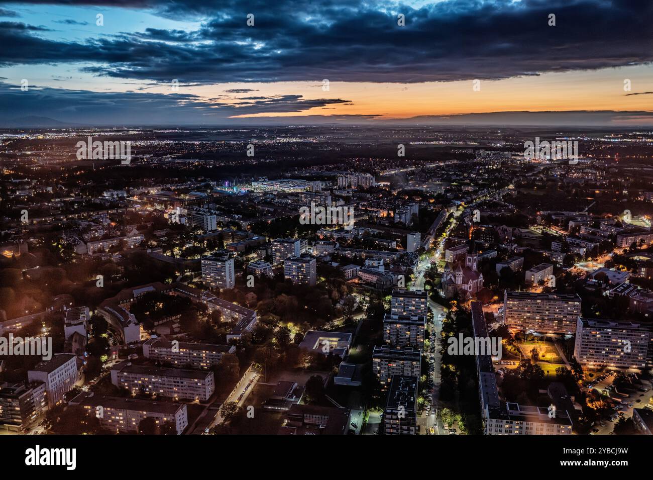 Une vue aérienne à couper le souffle d'un paysage urbain au crépuscule, mettant en valeur des rues et des bâtiments illuminés sous un ciel crépusculaire. L'image capture la vie urbaine et Banque D'Images
