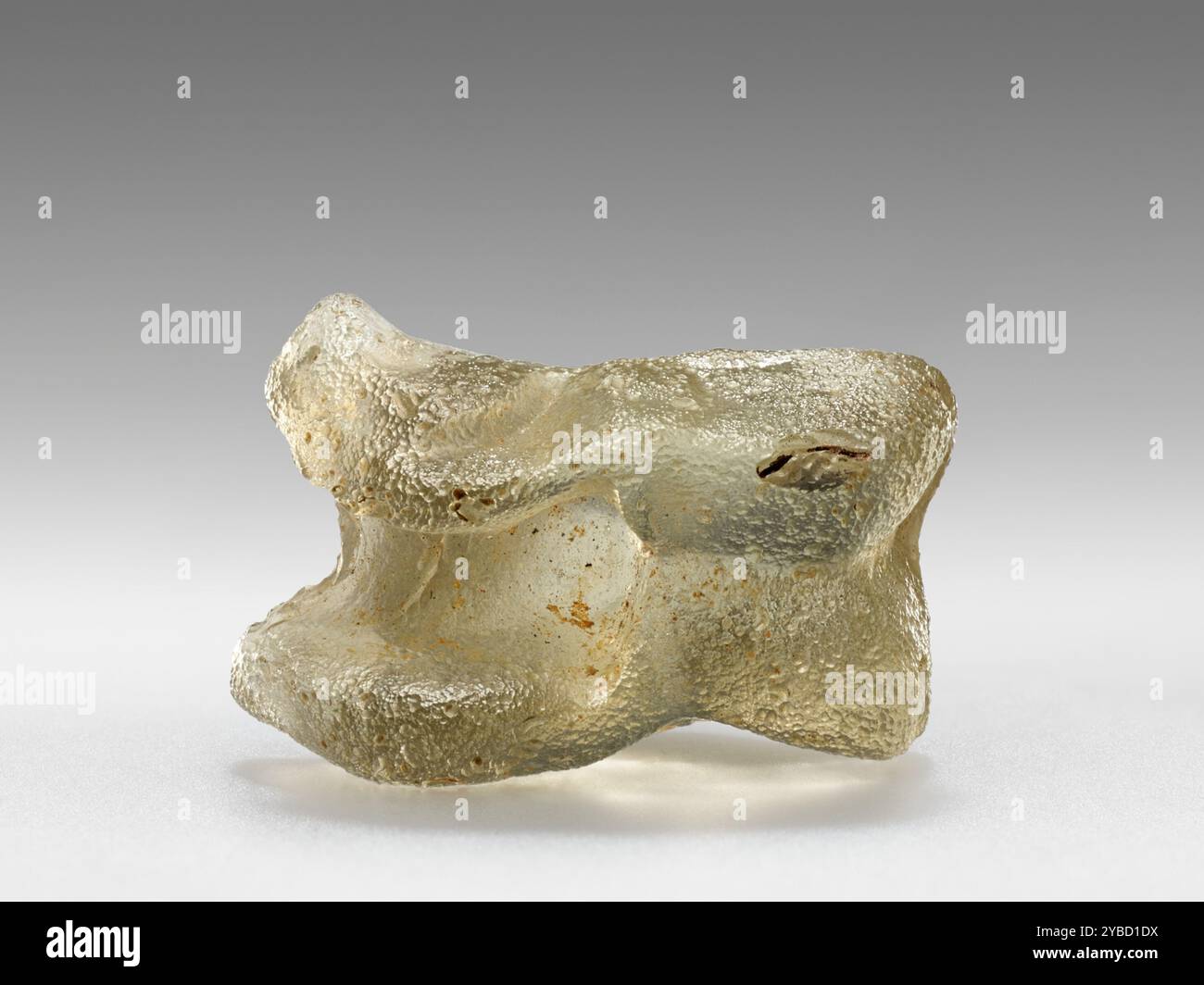 Astragalos, 1st Century B.C. - 1st Century A.D. informations supplémentaires : un des jouets les plus populaires parmi les enfants grecs dans l'antiquité était l'astragalos, ou Knucklebone. Typiquement, l'os de la cheville de la patte arrière d'une chèvre ou d'un mouton était utilisé. Mais cette pièce est faite de verre, moulée pour ressembler à un véritable squelette d'un animal. Les enfants ont roulé de l'astragaloi comme des dés. Chaque côté a reçu une valeur numérique unique. Comme les dés modernes, les valeurs sur les côtés opposés du jouet totalisent sept. Dans d'autres jeux, les joueurs tentent de frapper les articulations d'un adversaire hors du centre d'un cercle, ou de les jeter Banque D'Images