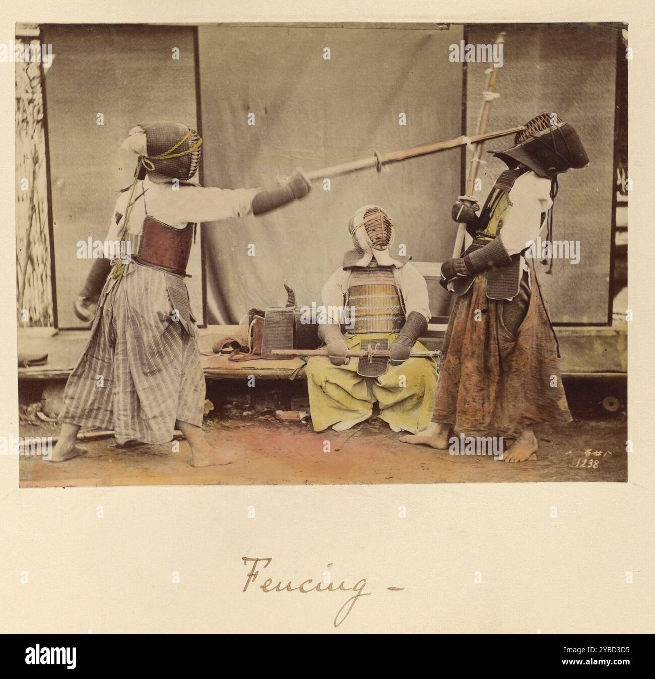 Escrime, vers 1873-1883. Deux hommes portant un équipement de protection clôturé avec de longs poteaux en bois. Un troisième homme, également en équipement de protection, s'assoit pour les observer. Banque D'Images