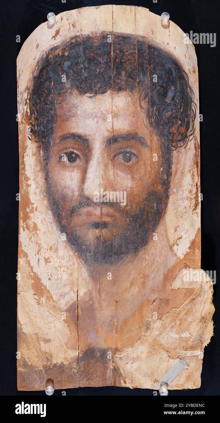 Portrait de momie d'un homme barbu, A.D. 140-160. Informations supplémentaires : en Egypte romaine, des portraits funéraires ont été peints sur des panneaux pour être placés sur les visages des morts et enfermés dans les emballages des momies en préparation de l'enterrement. La barbe luxuriante et pleine, les cheveux luxuriants et le regard profondément intense de ce jeune homme sont des traits stylistiques à la mesure de la sculpture de portrait masculin de la période Antonine (AD 138-192). Cela suggère une date au milieu du deuxième siècle, pour laquelle la datation au carbone 14 des textiles adhérant au panneau fournit un soutien supplémentaire. Banque D'Images